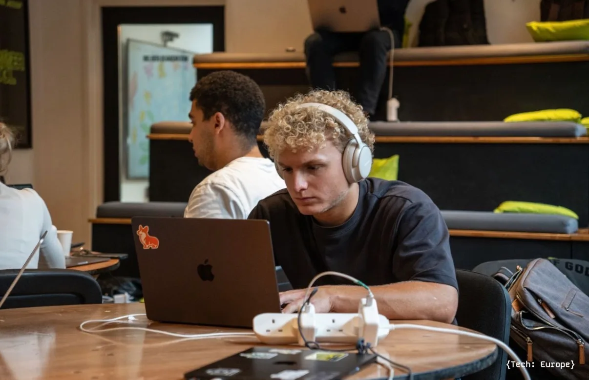 Ben Rowbotham, founder of rowbo.ai, working at a laptop at a hackathon in London.
